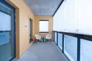 een balkon met 2 stoelen en ramen bij Lumiapartment1 in Rovaniemi