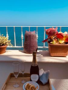 a table with a bottle of wine and glasses on a balcony at B&b Casa Maredentro in Monopoli