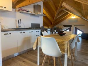 a kitchen with a table and chairs in a room at La Mansarda nel Borgo in Borgo Venusio