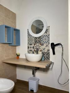 uma casa de banho com um lavatório e um espelho em Egadi Home em Favignana