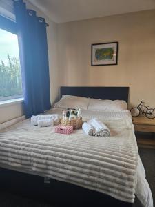 a bed with towels and a basket on it at Double bedroom located close to Manchester Airport in Wythenshawe
