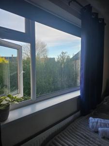 uma janela num quarto com uma cama e uma vista em Double bedroom located close to Manchester Airport em Wythenshawe