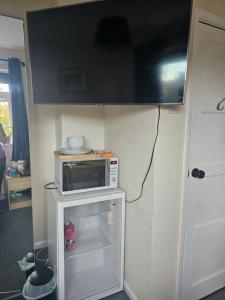 a microwave sitting on top of a small refrigerator at Double bedroom located close to Manchester Airport in Wythenshawe