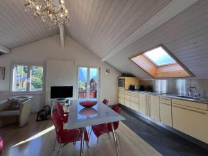 uma cozinha com uma mesa e cadeiras vermelhas num quarto em Chalet Tilia Penthouse em Wengen