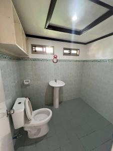 a bathroom with a toilet and a sink at Binucot Lodge in Romblon