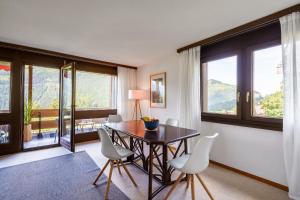 Un comedor con mesa y sillas y ventanas. en Chalet Krokus 6, en Wengen