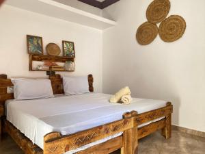 een slaapkamer met een houten bed in een kamer bij Palmsurfexpo in Imsouane