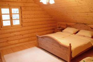 una camera con un letto in una baita di tronchi di Luxury Chalet at Podlipje Estate 