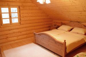 een slaapkamer met een bed in een blokhut bij Luxury Chalet at Podlipje Estate 