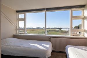 ein Schlafzimmer mit einem Bett und einem großen Fenster in der Unterkunft Vakantiehuis Rust in de onruste in Kamperland