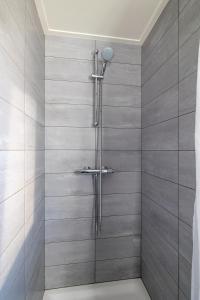 een douche met een glazen deur in de badkamer bij Vakantiehuis Rust in de onruste in Kamperland