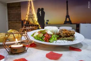 un plato de comida en una mesa frente a la torre Eiffel en Motel Casa de Pedra, en Caràzinho