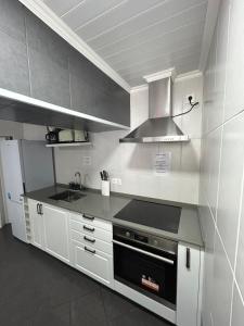 una cucina con armadi bianchi e piano cottura di Silva House Refuge ad Algarvia