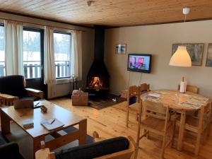 a living room with a table and a fireplace at Hemfjällsbyn 17A in Sälen