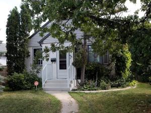 a white house with a stop sign in front of it at Cozy Airport 2-bed in Winnipeg