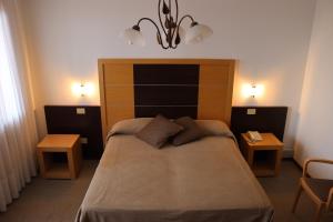 ein Schlafzimmer mit einem großen Bett mit zwei Tischen in der Unterkunft Albergo Alla Pineta in Montebelluna