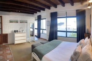een slaapkamer met een groot wit bed en ramen bij Casa palacio reformada S.XVIII in Sanlúcar de Barrameda
