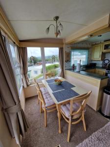 a kitchen and dining room with a table and chairs at Caravan F7 Aberystwyth holiday village in Aberystwyth