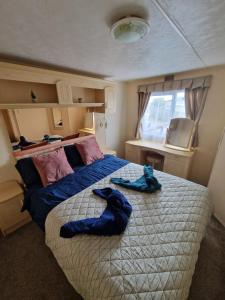 a bedroom with a large bed with blue towels on it at Caravan F7 Aberystwyth holiday village in Aberystwyth