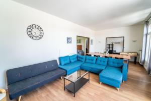 ein Wohnzimmer mit blauen Sofas und einem Tisch in der Unterkunft Appart Face Loire Blois Terrasse Parking Jardin Jacuzzi Parking Vélos in Blois