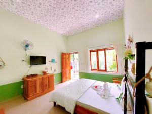 a bedroom with a bed and a tv on the ceiling at Ben Guesthouse Phu Quoc in Phú Quốc