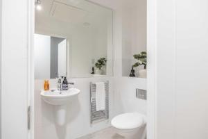 a white bathroom with a toilet and a sink at Charming 1BR Apartment Near Windsor Castle in Windsor