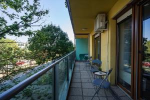 a balcony with chairs and tables on a building at Panna Marina Apartment by NW in Budapest