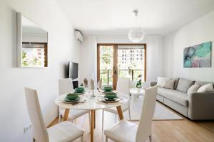 a white living room with a white table and chairs at Panna Marina Apartment by NW in Budapest