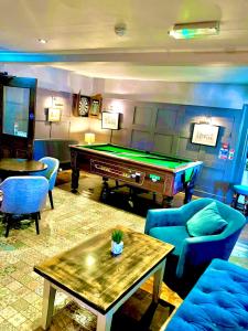 a living room with a pool table and blue chairs at Three Tuns Ashwell in Ashwell