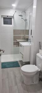 a bathroom with a toilet and a sink and a shower at Chinde Guesthouse in Lisbon