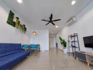 a living room with a blue couch and a ceiling fan at 3 Elements* The Garden* MRT2* Wifi* Self Check-In in Kampong Batu Sembilan