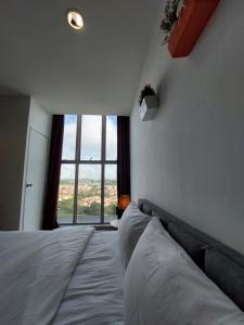 a bedroom with a large bed with a large window at 3 Elements* The Garden* MRT2* Wifi* Self Check-In in Kampong Batu Sembilan +19 photos