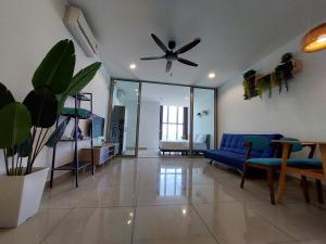 a living room with a blue couch and a ceiling fan at 3 Elements* The Garden* MRT2* Wifi* Self Check-In in Kampong Batu Sembilan