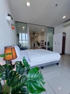 a bedroom with a white bed and a plant at 3 Elements* The Garden* MRT2* Wifi* Self Check-In in Kampong Batu Sembilan