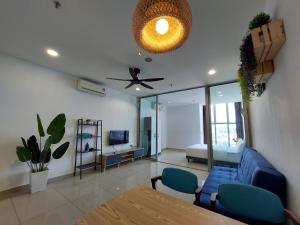 a living room with a blue couch and a ceiling fan at 3 Elements* The Garden* MRT2* Wifi* Self Check-In in Kampong Batu Sembilan