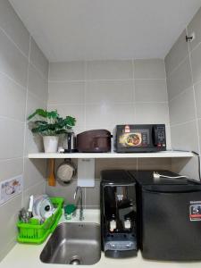 a kitchen with a sink and a coffee maker on a shelf at 3 Elements* The Garden* MRT2* Wifi* Self Check-In in Kampong Batu Sembilan