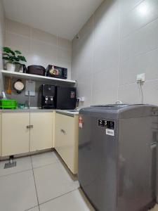 a kitchen with a dishwasher in the middle of a room at 3 Elements* The Garden* MRT2* Wifi* Self Check-In in Kampong Batu Sembilan
