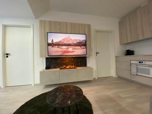 ein Wohnzimmer mit einem Flachbild-TV über einem Kamin in der Unterkunft Loft Vrchlabí in Vrchlabí
