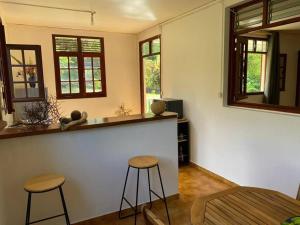 a room with two stools and a counter with a mirror at Zayann Zen in Gourbeyre