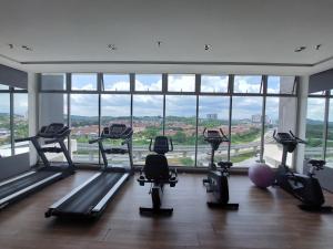 a gym with several treadmills in a room with windows at 3 Elements* The Garden* MRT2* Wifi* Self Check-In in Kampong Batu Sembilan