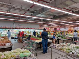 a group of people shopping in a grocery store at 3 Elements* The Garden* MRT2* Wifi* Self Check-In in Kampong Batu Sembilan