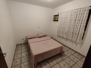 een kleine kamer met twee bedden en een raam bij Casa Amarela in Navegantes +13 foto's
