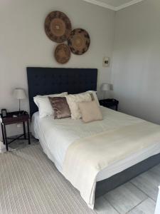 a bedroom with a large bed with pillows on it at Whitehouse cottage in White River +21 photos