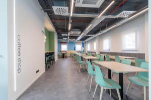 an empty room with tables and chairs at Micampus Getafe II Student Residence in Getafe