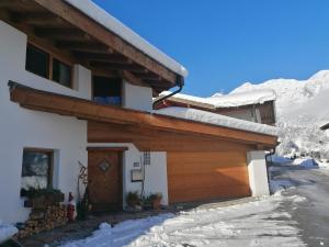 dom ze śniegiem na dachu w obiekcie Haus Miriam w mieście Mieming