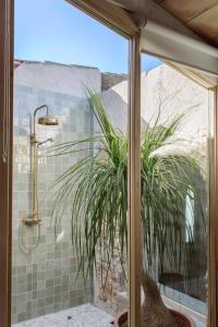 a bathroom with a shower with a plant in it at C'an Talaieta Luxurious Farmhouse in S'Horta