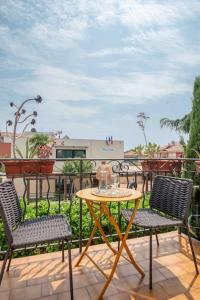 a patio with a table and two chairs and a table at Appartement climatisé en plein centre avec balcon in Saint-Jean-Cap-Ferrat