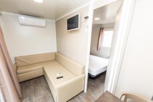 a small room with a couch and a bed at Camping Bellsol Pets in Pineda de Mar