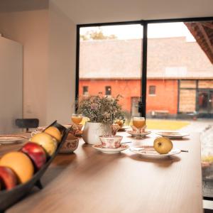 einen Tisch mit Teller mit Lebensmitteln und ein Fenster in der Unterkunft Lozerkasteel in Kruishoutem