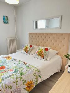 a bed with two pillows on it in a bedroom at Résidence des Sources in Vichy